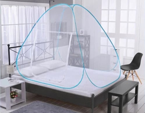 Pop up mosquito net set up over a bed