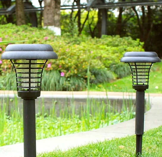 Solar bug zapper lamps staked in a garden